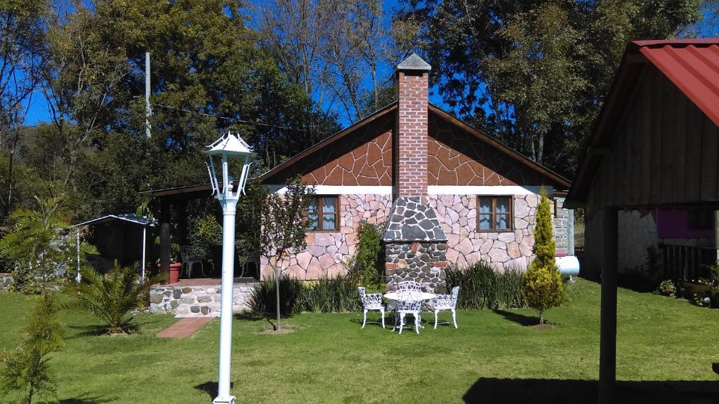 a house with a table and chairs in front of it at Cabañas Cumbres de Aguacatitla in Huasca de Ocampo