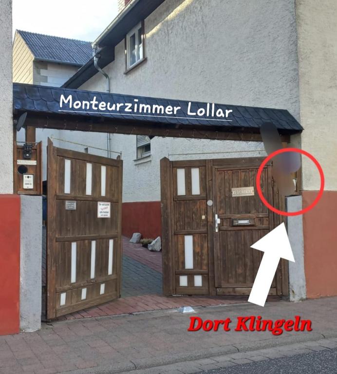 a pair of wooden garage doors with a white arrow at Monteurzimmer Lollar in Lollar