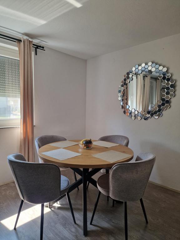a dining room table with chairs and a mirror at Miljana in Vukovar