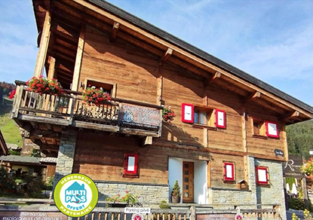 a log house with a balcony and a sign at Morzine Guest Chalet Alpine Vibes - Spa - Sauna - Premium Location in Morzine