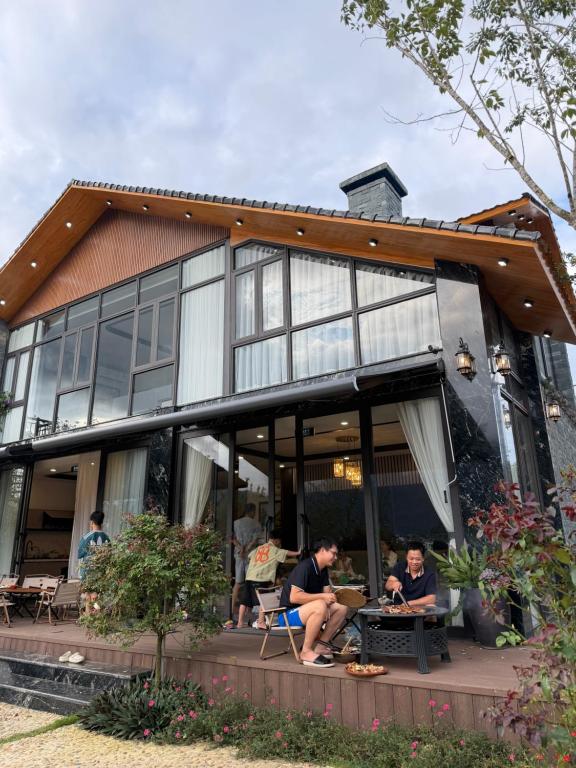 two people sitting at tables outside of a house at Sun Hill Villa in Lao Cai