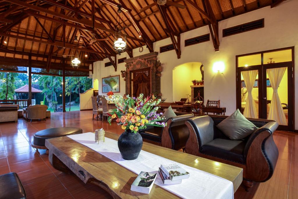 a living room with a vase of flowers on a table at Banyualit Spa 'n Resort Lovina in Lovina