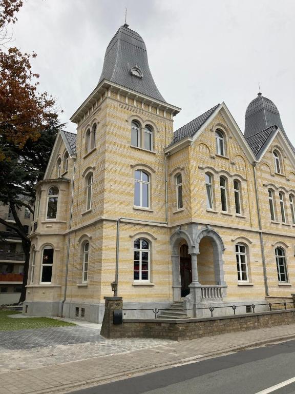 a large brick building with a tower on a street at Spacious apartment in an authentic Mansion in Brussels