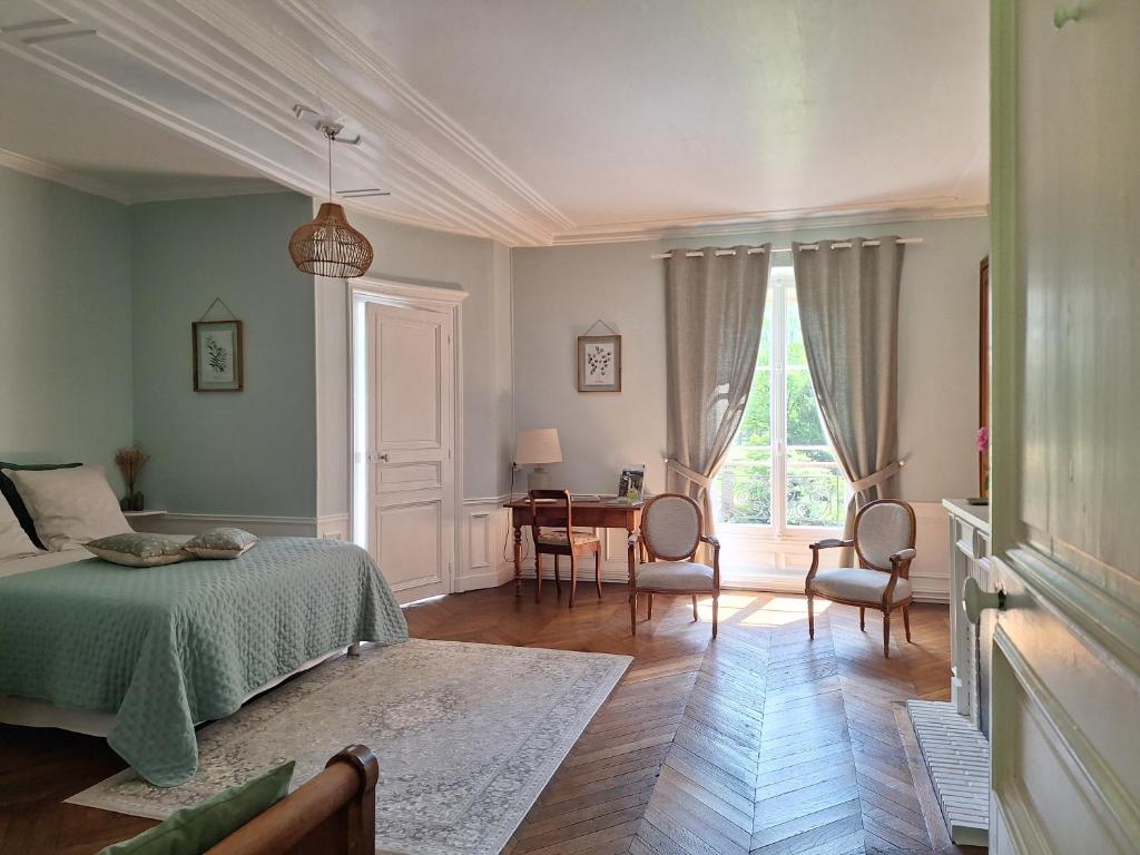 a bedroom with a bed and a table with chairs at Chambre d'hôtes du Château de Digeon in Morvillers-Saint-Saturnin