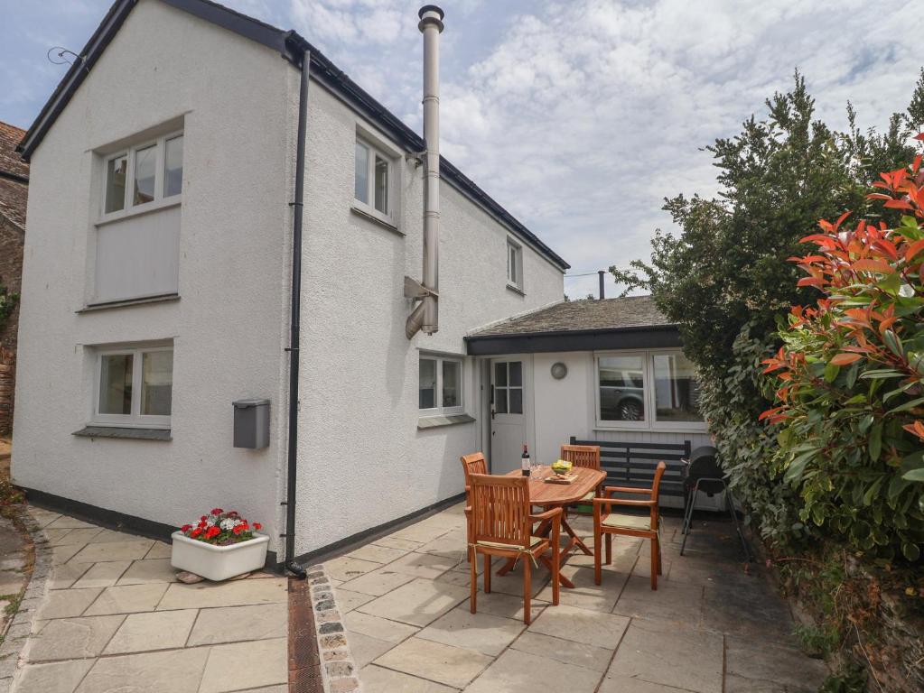 a patio with a table and chairs in front of a house at Wrens Nest in Kingsbridge