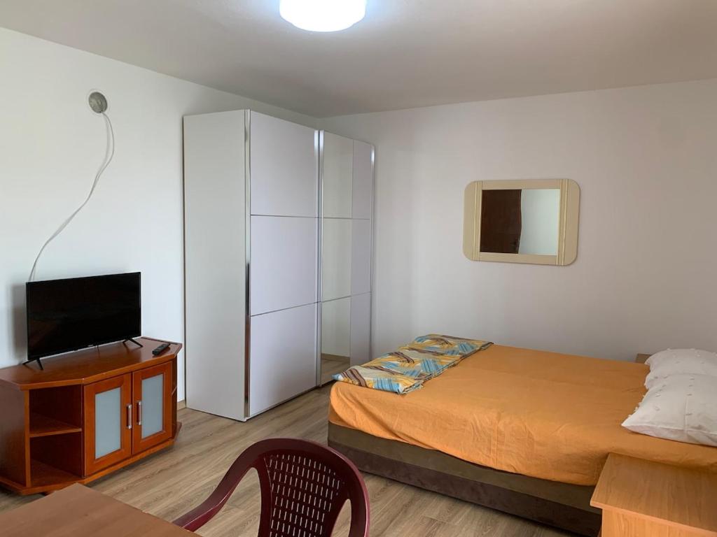 a bedroom with a bed and a tv and a cabinet at Vila Nikolic in Lastva