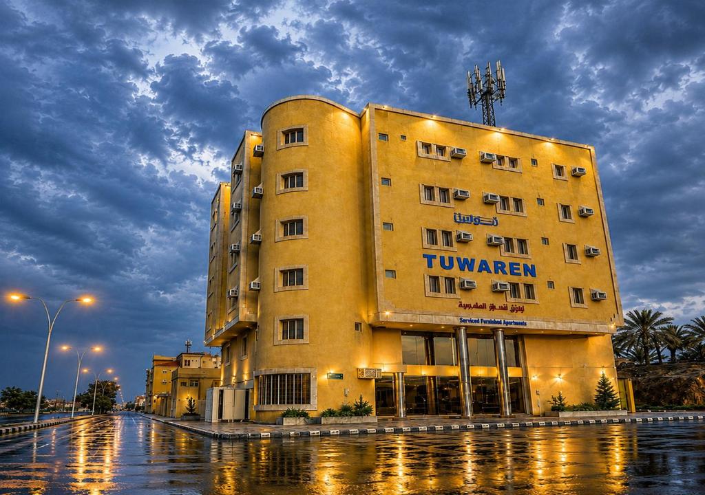 a large yellow building in the middle of a street at توارن للشقق المخدومة - اقتصادي in Hail
