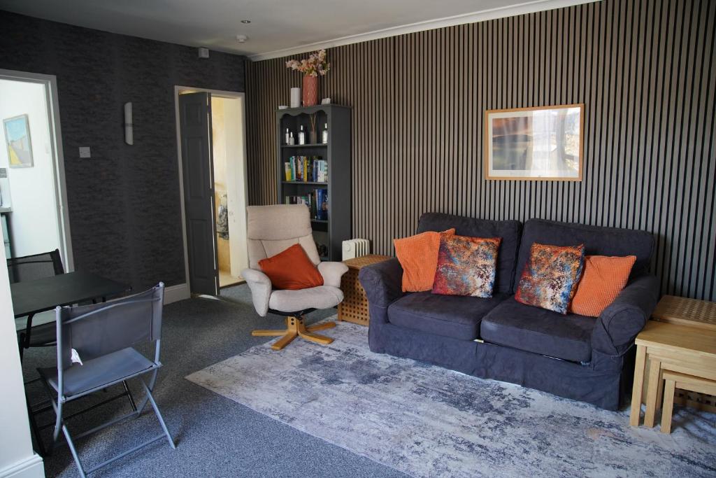 a living room with a blue couch and a chair at Seaford Snug in Seaford