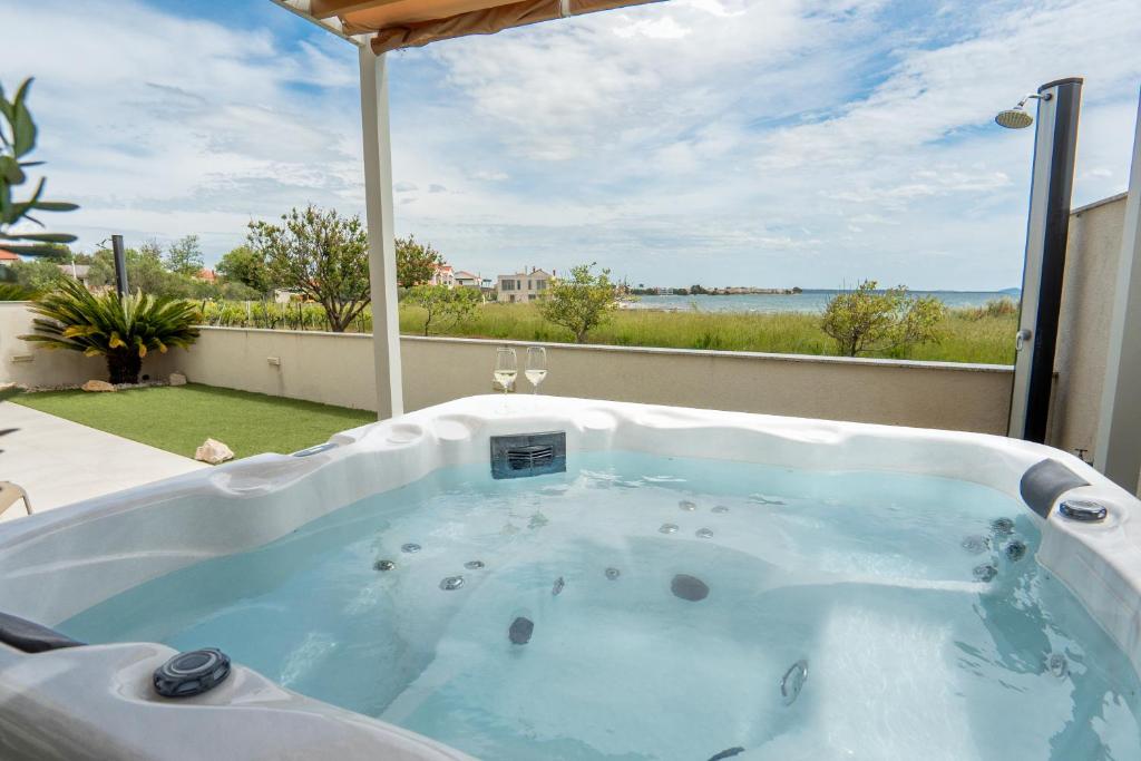 a jacuzzi tub with a view of the water at Beachfront Reiterer Villa V1 with Jacuzzi 30 meters from the Beach - CROWONDER LUXURY RENT in Privlaka