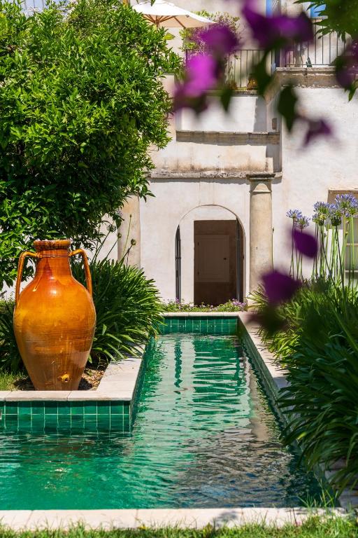 a large vase sitting next to a swimming pool at Palazzo Muci in Nardò