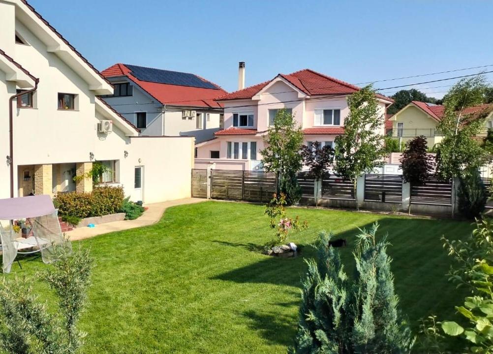 a large yard with a fence and a yard sidx sidx sidx at Bungalow Ildy House in Sînmartin