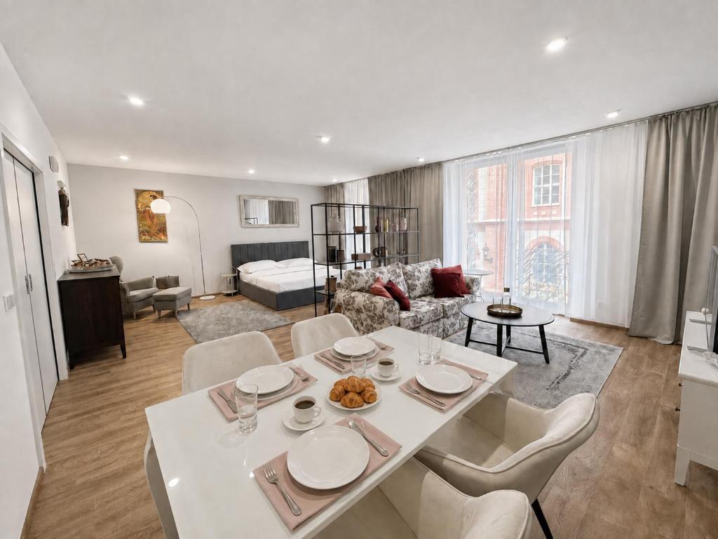 a white table and chairs in a living room at Veleslaveenka - Spacious Apartment in Pilsen Old Town in Pilsen