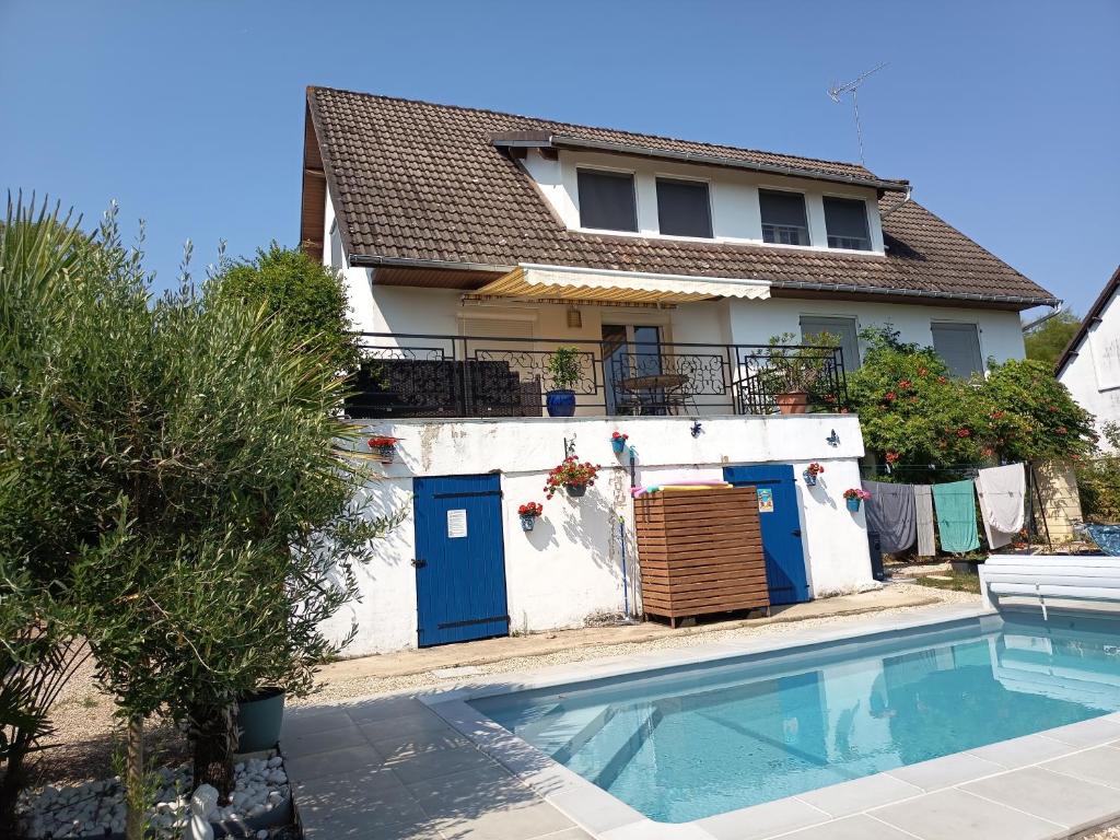 a house with a swimming pool in front of a house at Chambres d'hôtes des Bruyères in Collemiers