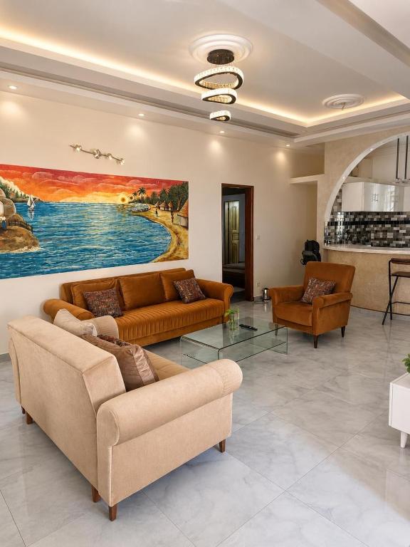 a living room with couches and a painting on the wall at Résidence Les Bernier in Nianing