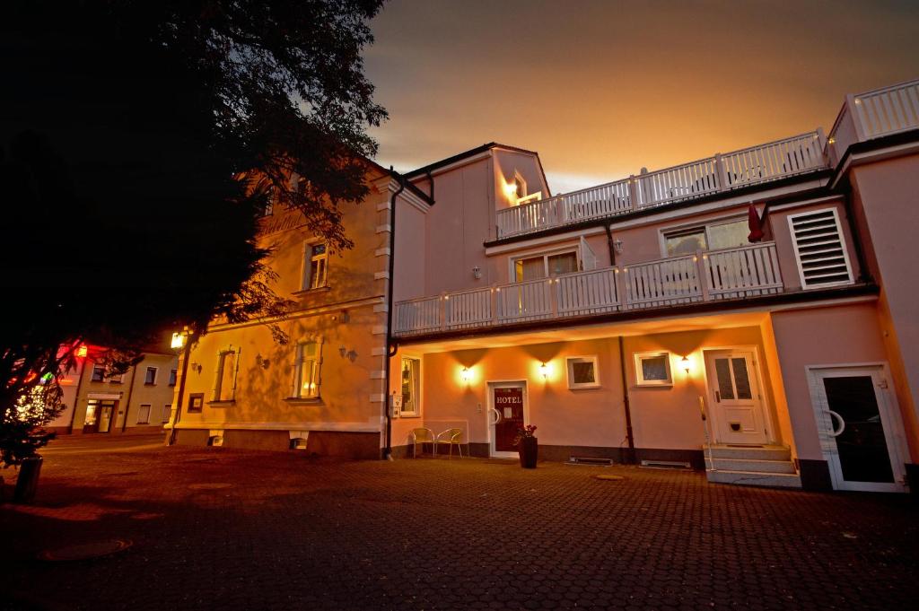 a building with a balcony on top of it at night at Hotel Carl von Clausewitz in Leipzig