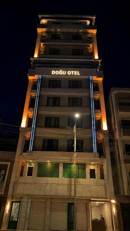 a tall building with a sign on it at night at Otel OrtaDoğu in Urfa