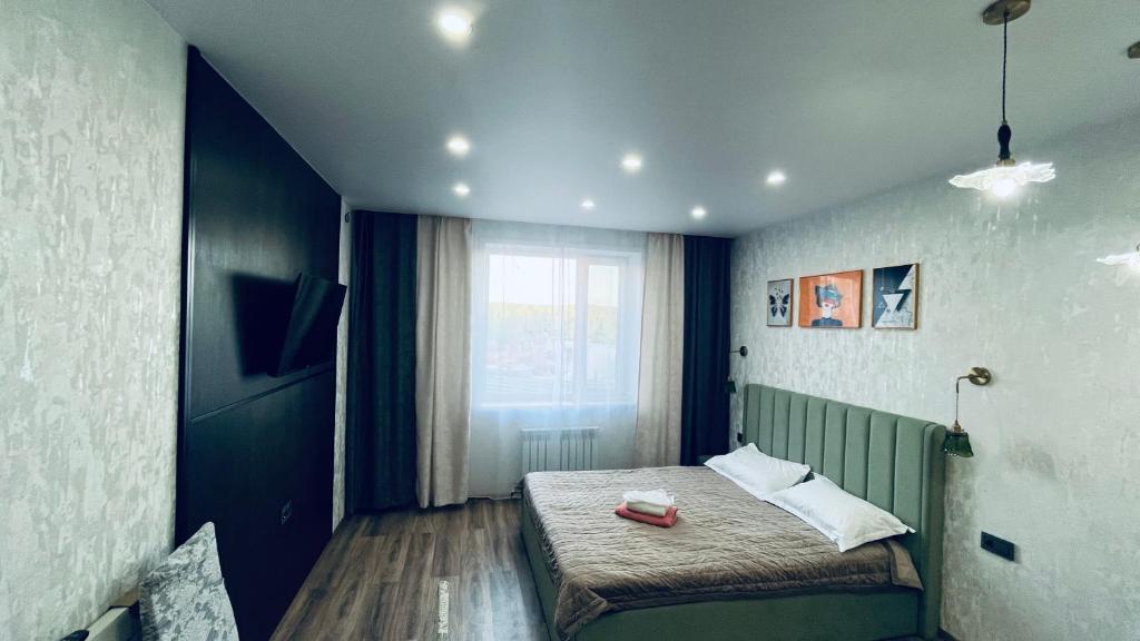 a bedroom with a bed and a window at ЖК Табигат in Borovoye