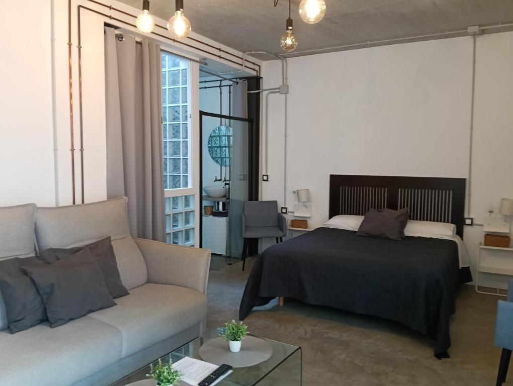 a living room with a bed and a couch at Corredera Travel 2 in Córdoba