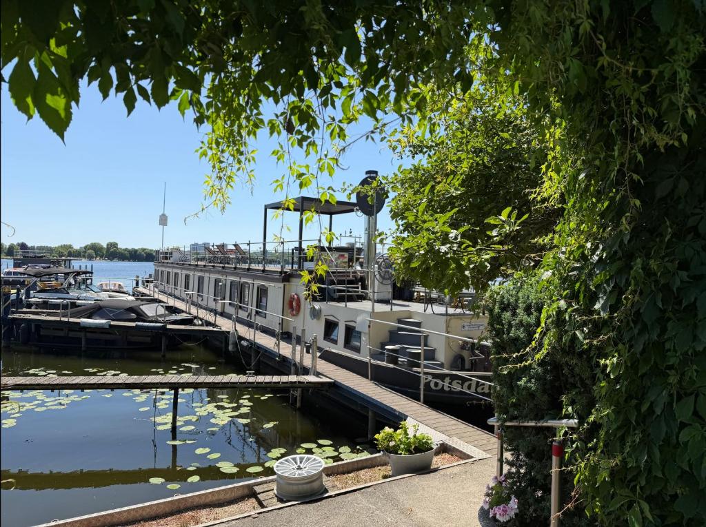 a boat docked at a dock on the water at Schiffspension Luise in Potsdam