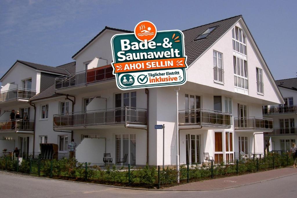 a sign in front of a large white building at Ostseebrise - Bade- & Saunawelt täglich inklusive in Thiessow
