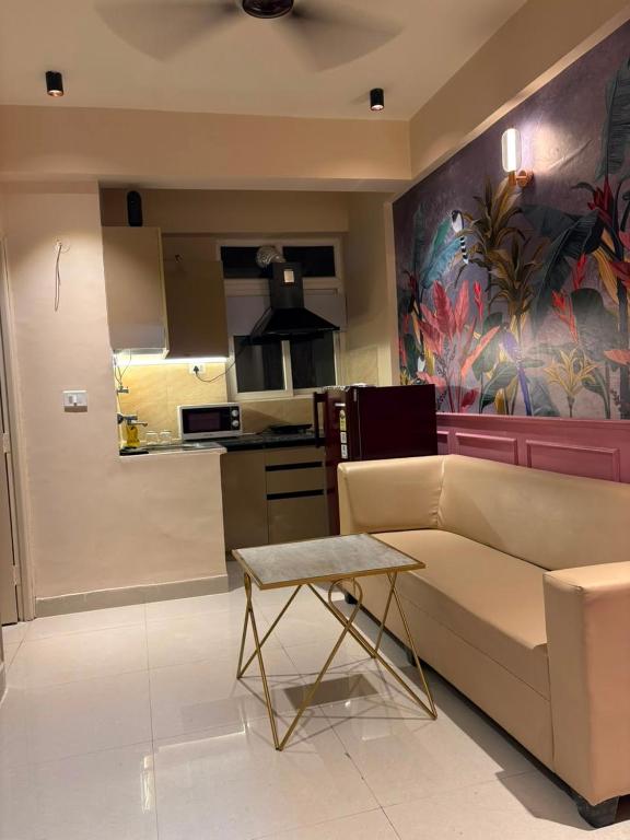 a living room with a couch and a kitchen at Bright & Modern 1BHK in Ghaziabad
