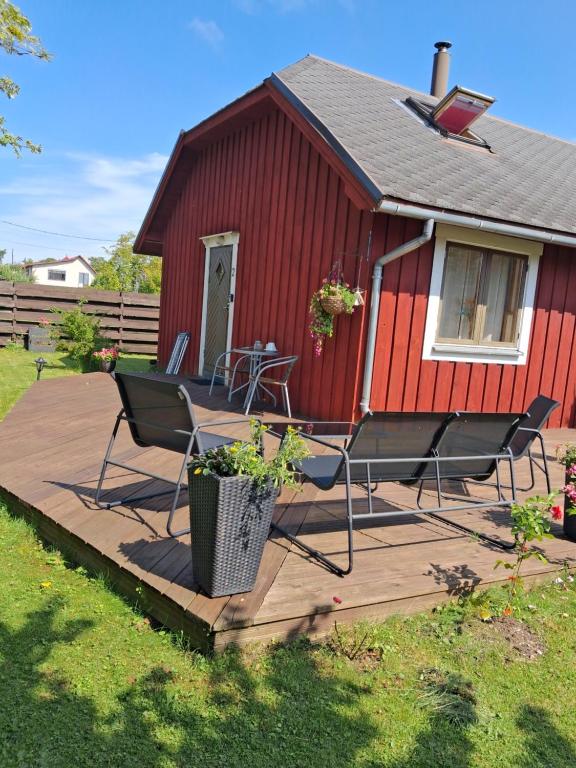 a deck with chairs and a table in front of a red building at Villa Aili in Pärnu
