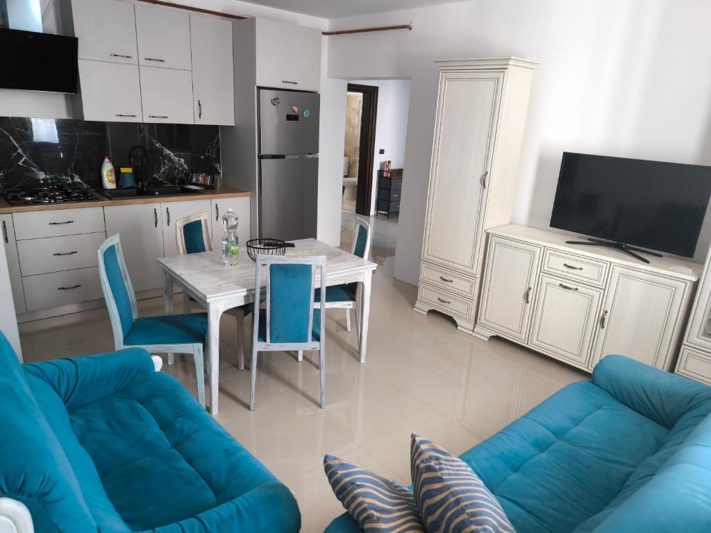 a living room with a blue couch and a table at Apartament cu 2 camere situat la etajul al doilea in Rădăuţi