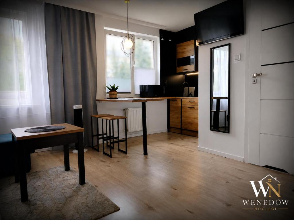 a living room with a table and a kitchen at 104 Wenedów Noclegi in Koszalin
