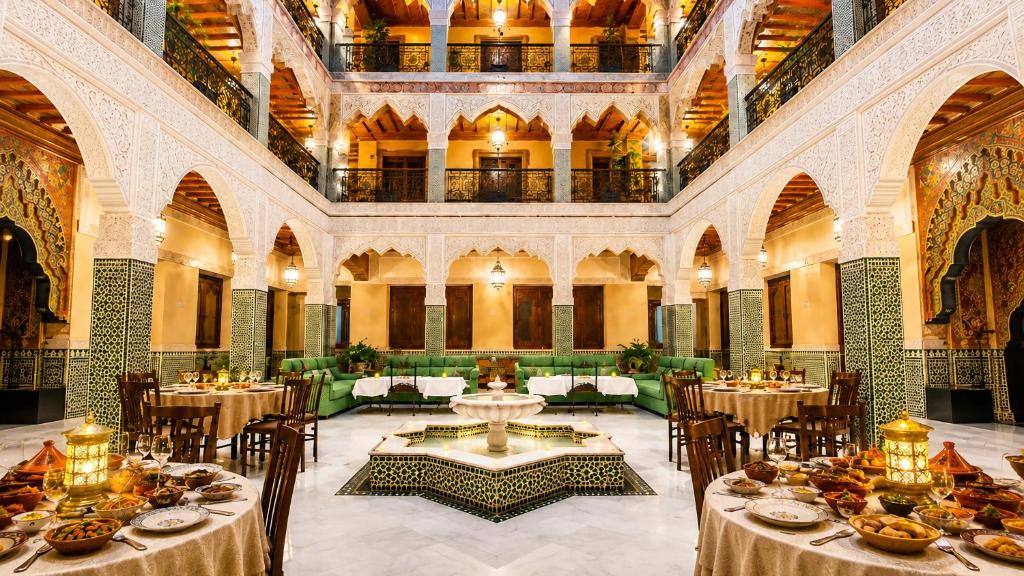 a dining room with tables and chairs in a building at Palais Riad Reda & Spa in Fez