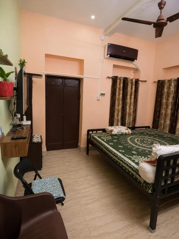 a bedroom with a bed and a desk and a tv at Jagdamba Bhawan in Kolkata