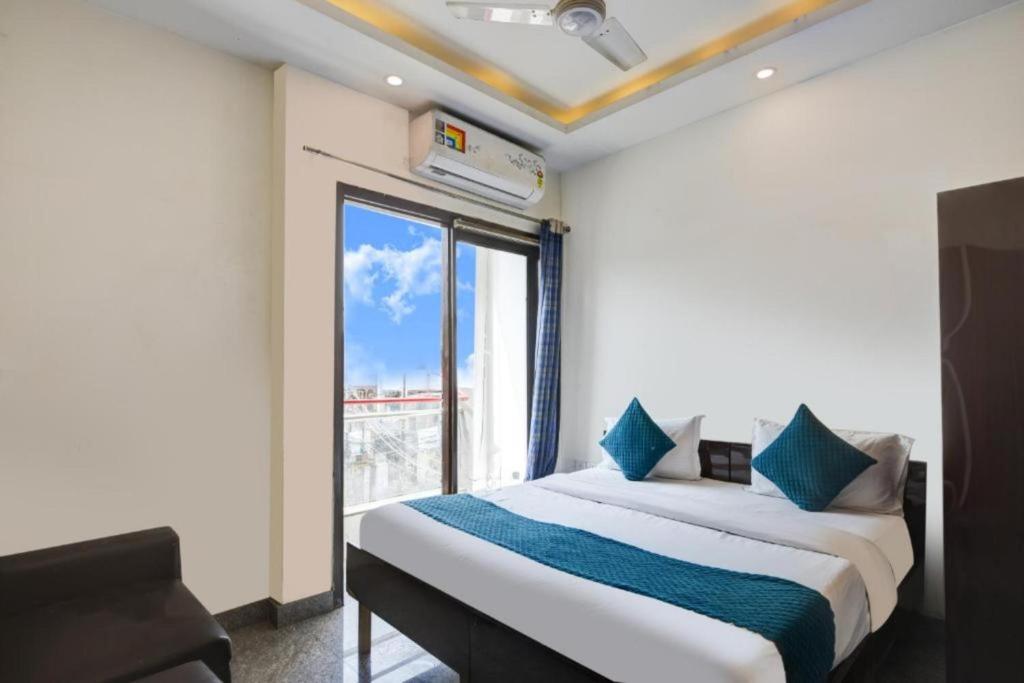 a bedroom with a bed with a large window at Hotel Bir Stay- Near Nizamuddin Dargah in New Delhi