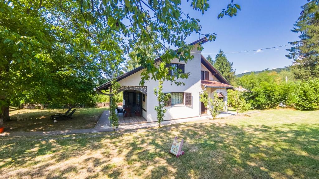 a small white house with a yard at Gorska Vila Sisevac in Sisevac