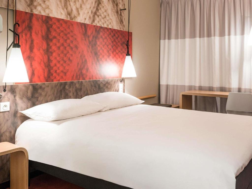 a bedroom with a large white bed and a flag at Ibis Rabat Agdal in Rabat