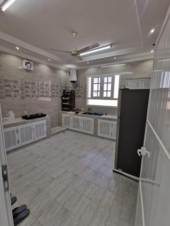 a large kitchen with white cabinets and a large room at شاليه شاطئ خلوف in Khalūf