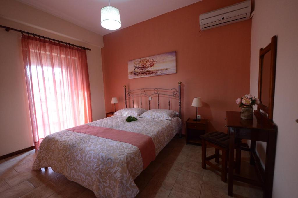 - une chambre avec un lit, une table et une fenêtre dans l'établissement Alexandra Spingou Apartments, à Dassia