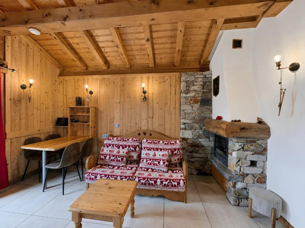 a room with a bed and a table and a fireplace at Le Tyrol in La Plagne Tarentaise
