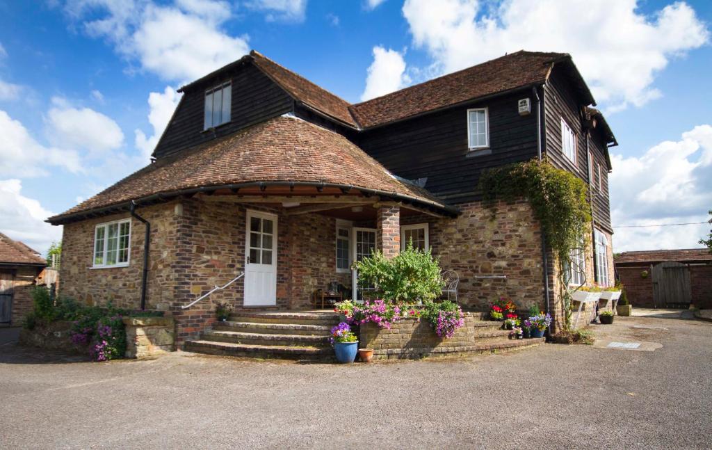 a large brick house with a white door at Magpies Lodge in Slinfold