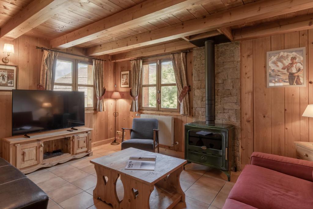 a living room with a fireplace and a stove at Petit Bois - by Care Concierge in Demi-Quartier