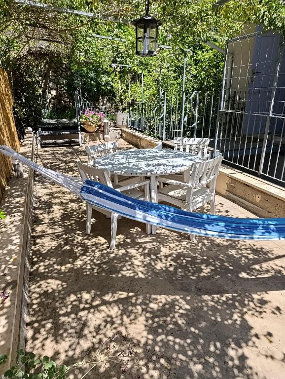 a table and chairs with a blue surfboard on a patio at הקן לציפורים נודדות in Rosh Pinna