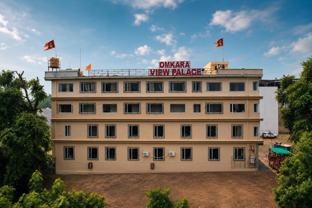 a building with two flags on top of it at Hotel Omkara View Palace in Godarpura