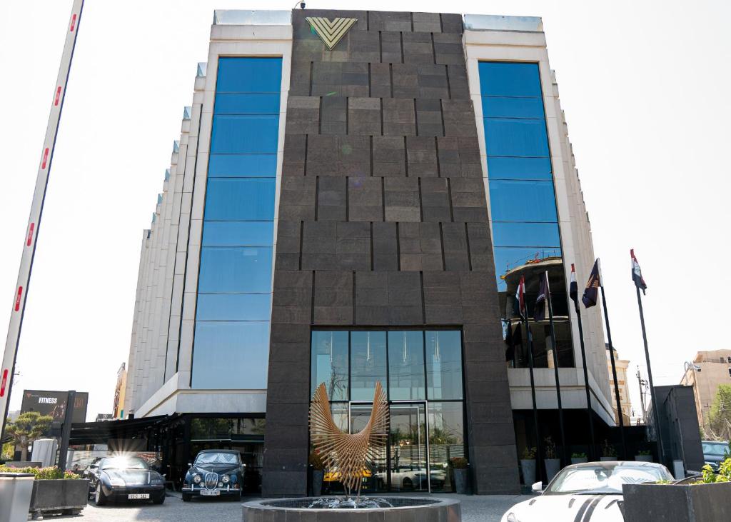 a building with a bird statue in front of it at The V Hotel in Baghdād