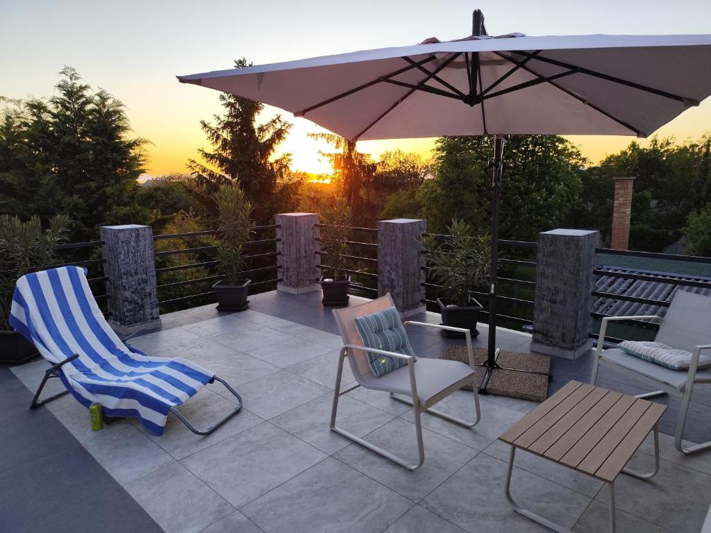 a patio with two chairs and an umbrella at Norbi Vendégház in Balatonszárszó