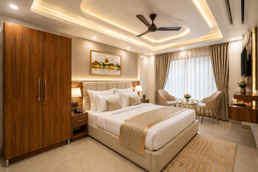 a bedroom with a large bed with a ceiling fan at Hotel Grand Villa Suites Near Delhi International, IGI Airport in New Delhi