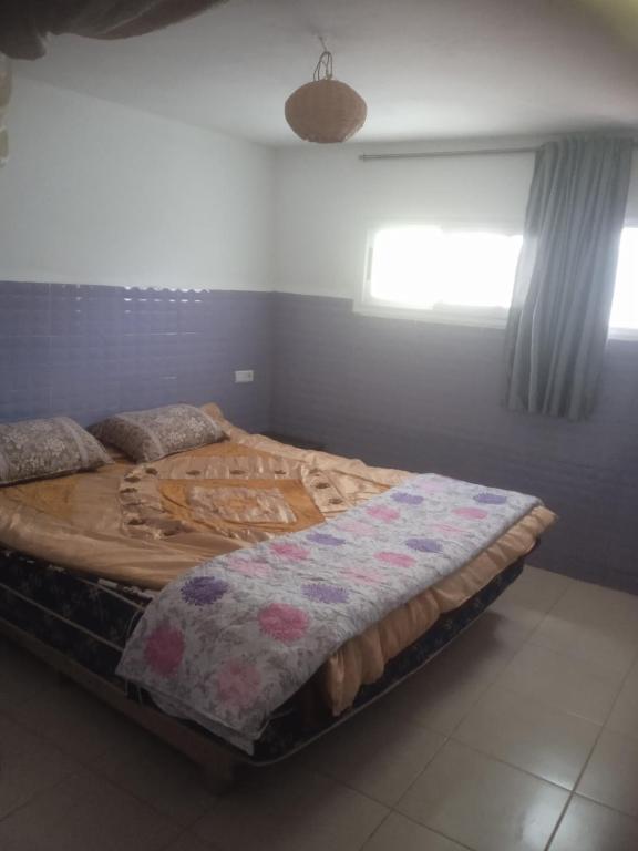 a bedroom with a large wooden bed in a room at Tamraght banana house in Agadir
