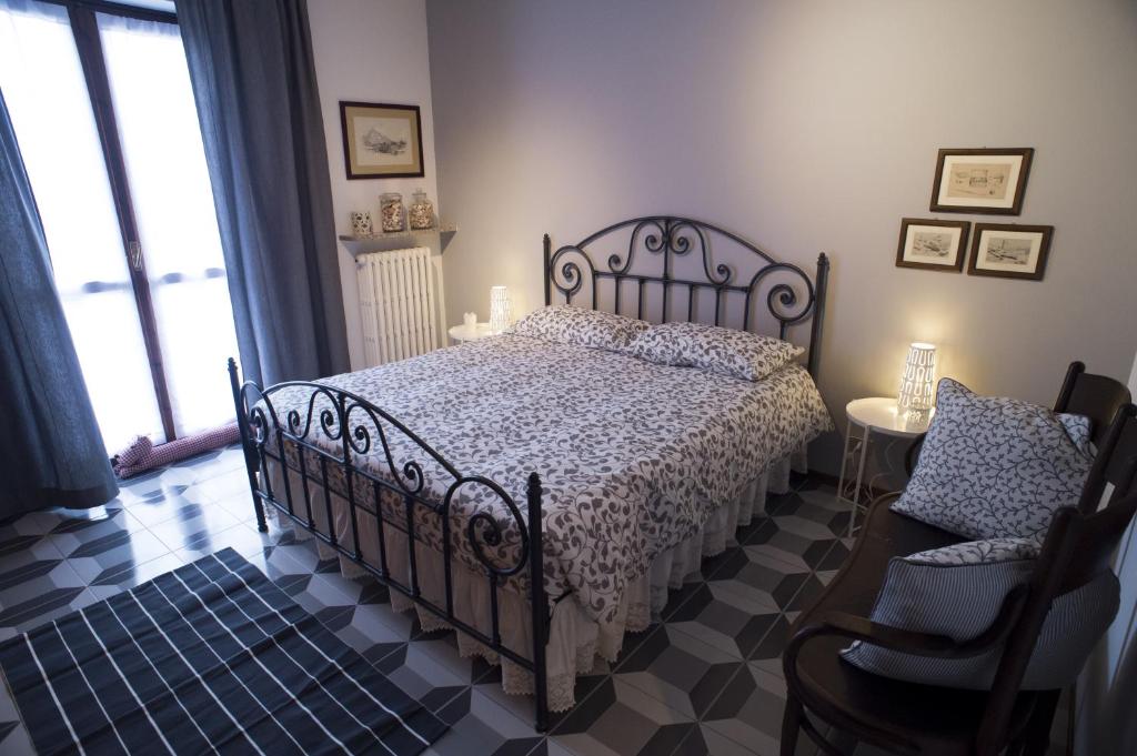 - une chambre avec un grand lit et une chaise dans l'établissement Casa Clementi, à Barolo