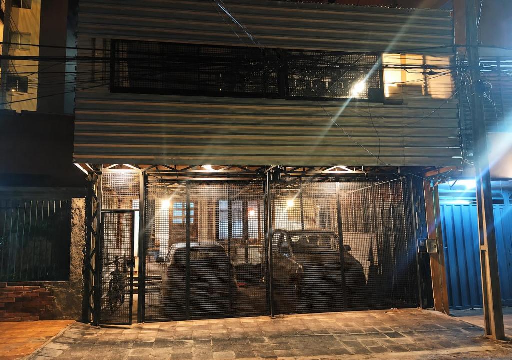 an iron gate in front of a building at night at Departamento Monoambiente Rústico in Asunción