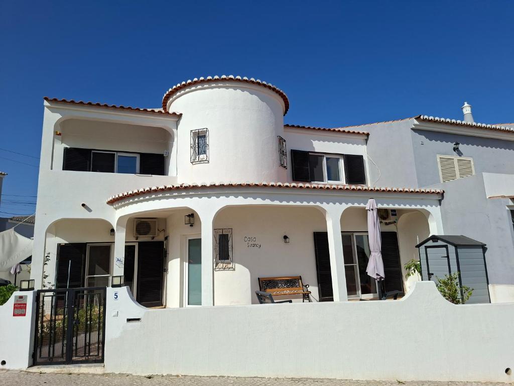 a large white house with a fence in front of it at Casa Svancy in Lagoa
