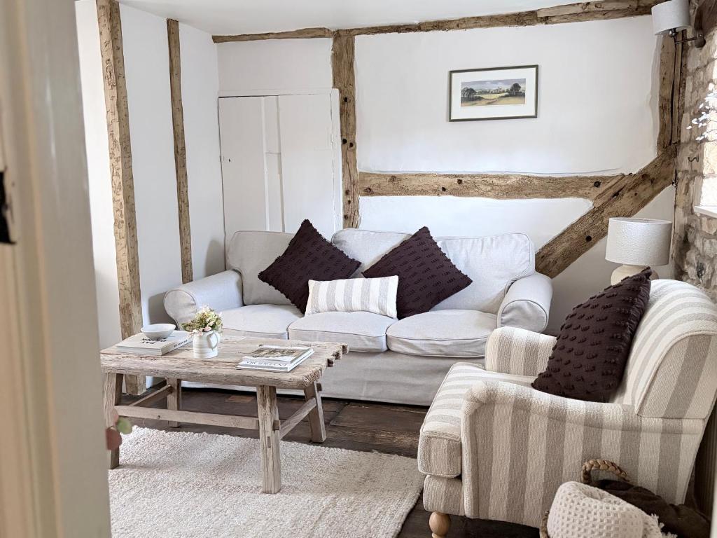 a living room with a couch and a table at Castle Cottage Winchcombe in Winchcombe