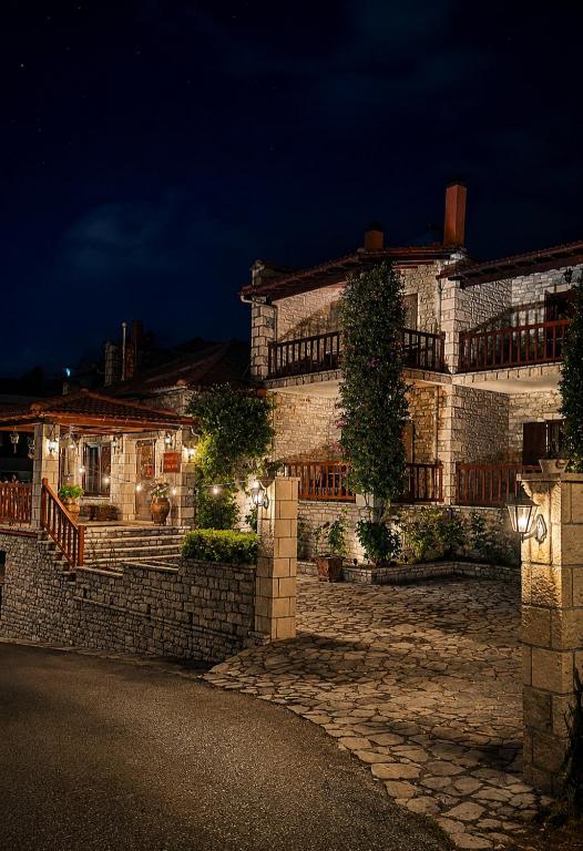 a large stone building with lights on it at night at Village Inn in Ano Chora