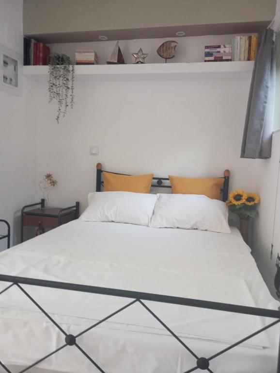 a bedroom with a bed with white sheets at Basic in Kalamata